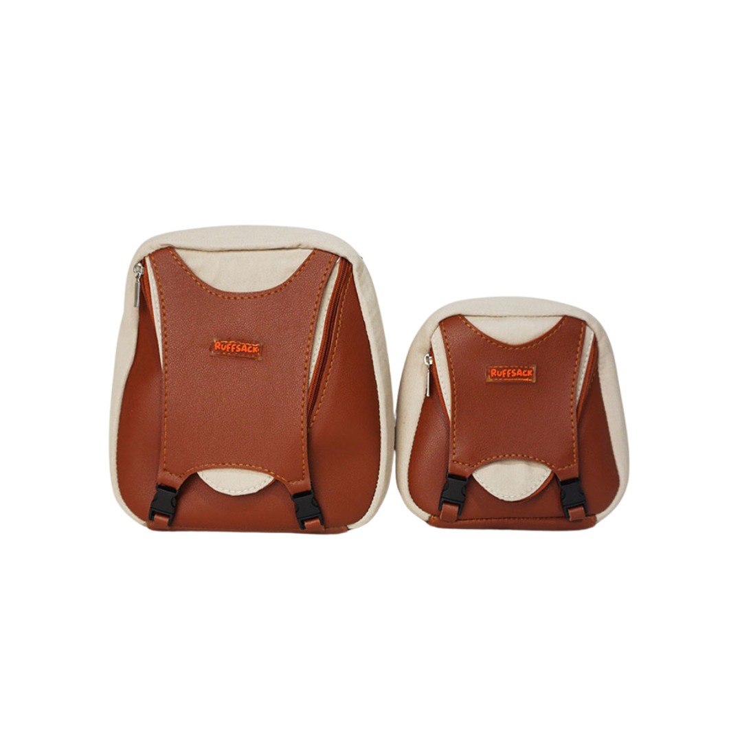 Reed model Ruffsack backpack front angle. The backpack features a dark tan fabric atop a light tan fabric. A zipper and clips along the front center allow access to the inside.