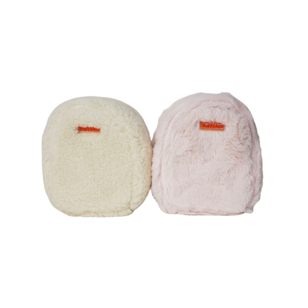 Funny Fur White and Pink model Ruffsack backpacks. The backpacks feature a furry, fluffy fabric in either white or pink. A side zipper allows access to the inside.