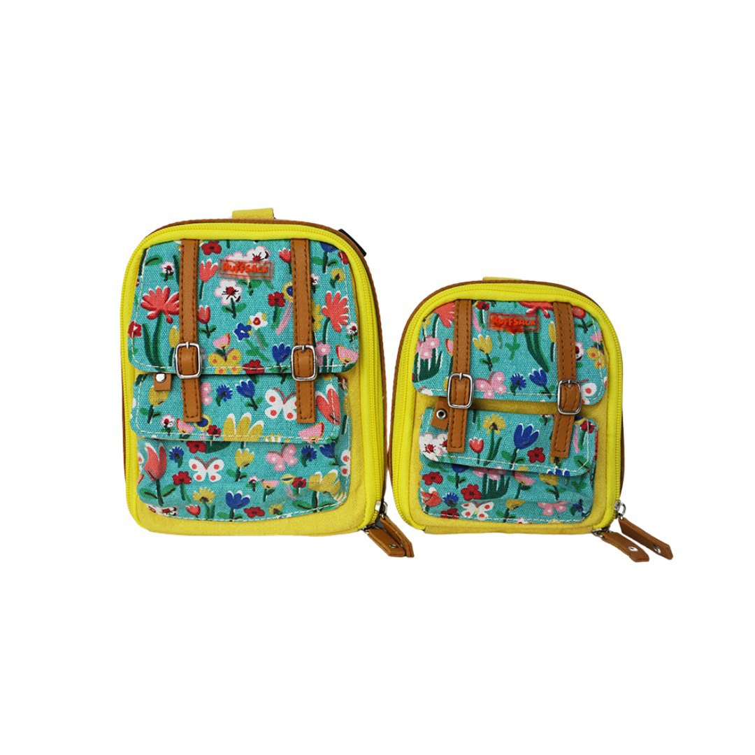 Dale Floral model Ruffsack backpack at front angle. The backpack face features a cotton floral pattern with two small front buttoned pockets. Tan faux leather accents are on the front and sides of the bag. A side zipper allows access to the inside.