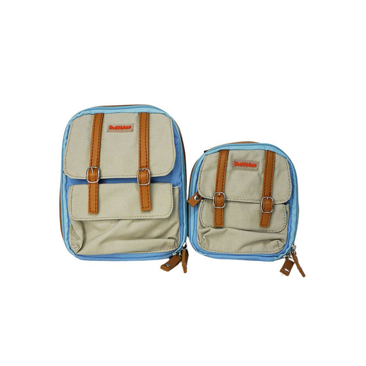 Dale Light Blue model Ruffsack backpack front angle. The backpack face features a cotton gray solid pattern with two small front buttoned pockets atop a cotton light blue solid pattern. Tan faux leather accents are on the front and sides of the bag. A side zipper allows access to the inside.