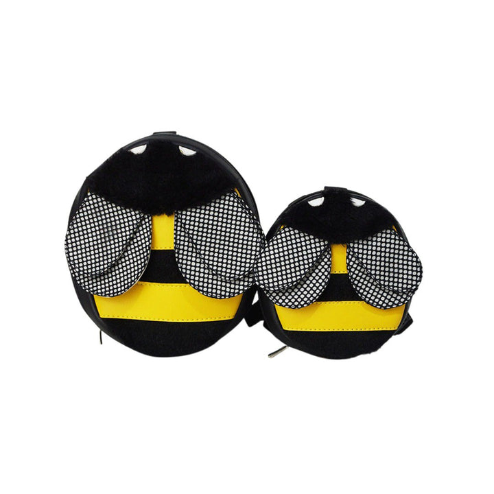 Bumble Bee model Ruffsack backpack front angle. The backpack features an oval bumble bee shape made with faux leather yellow stripes,  furry black stripes, textured wings, black head, and white eyes. A side zipper allows access to the inside.